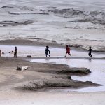 Children play without fearing the threat of floods on the banks of the Indus River near Jamshoro