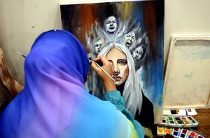 A female artist showcases her talent on canvas during an art competition titled "Human Rights", held at Book Studio under the patronage of the Academy of Arts, Fermanite School System, and Book Studio.