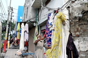 A vendor displays cloth curtains at his roadside setup to attract the customers.
