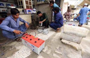 A mechanic repairs batteries at his roadside workshop near Charsadda Road.