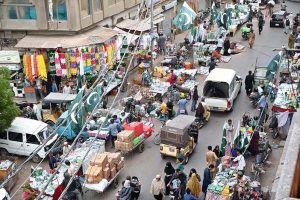A vendor displays Independence Day-themed girls’ shirts, national flags, and badges at Paper Market as preparations for Independence Day celebrations gain momentum