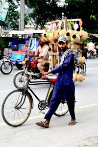 A street hawker on his way to sell artificial bird nests displayed on his bicycle.