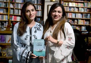 Author Saira Sheikh presents a signed copy of her debut book Healing in the Shadow of Loss to Lala Rukh Dhar, Director, ECO Postal Staff College at Biblio Café.