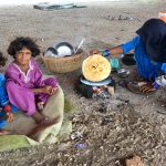 A gypsy woman preparing Roti (bread) for her children under the flyover at Qasimabad