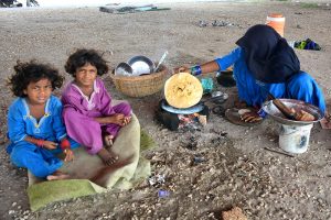 A gypsy woman preparing Roti (bread) for her children under the flyover at Qasimabad