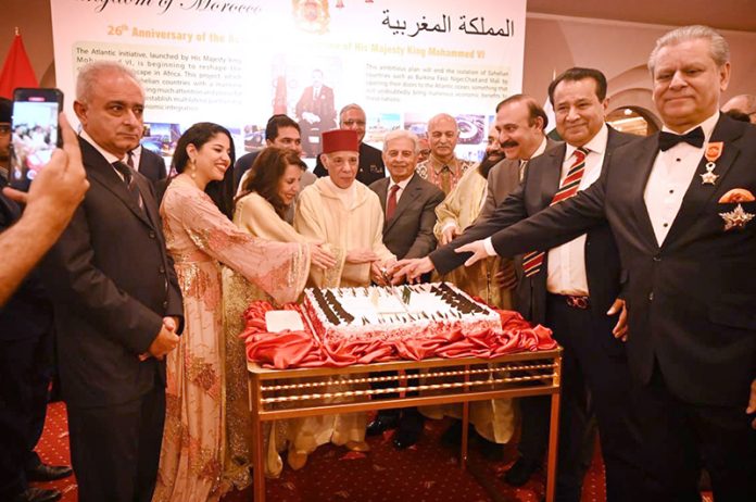 Federal Minister for National Food Security and Research, Industries and Production, Rana Tanveer Hussain along with The Ambassador of the Kingdom of Morocco and Mrs Mohamed Karmoune and other dignitaries cutting cake on the occasion of the Twenty Sixth Anniversary of the Accession to The Throne of King Mohammed VI of Morocco at a local hotel
