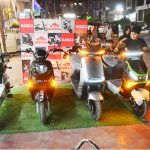 Children showing interest in electric bike displayed at a vendor’s bike showroom at Latifabad