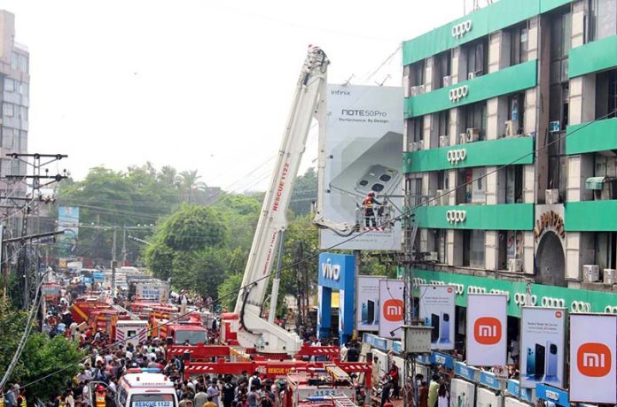 Rescue workers struggle to extinguish a fire that broke out at Hafeez Center in Gulberg