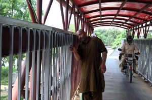 Worker busy painting a pedestrian bridge at Zero Point in the Federal Capital.