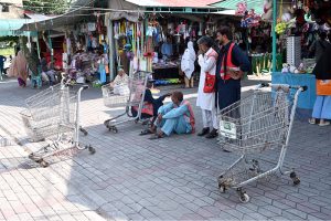 Daily wage labourers with their luggage carrier carts wait for customers at H-9 Weekly Bazaar