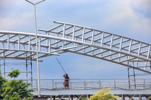 A labourer is busy paint the overhead bride for pedestrian on Islamabad Expressway in Federal Capital.