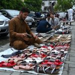 Vendors sell sandals at a roadside stall near G-9 to attract customers in the Federal Capital
