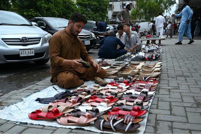 Vendors sell sandals at a roadside stall near G-9 to attract customers in the Federal Capital