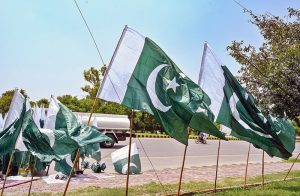 A vendor displaying national flags and other items to attract the customers at his roadside setup in connection with upcoming Independence Day celebrations in Federal Capital.