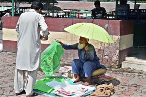 An elderly vendor selling shopping bags outside Aabpara Sunday Bazaar in the Federal Capital.