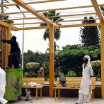 A labourer busy painting a bus stop shed on Murree Road near Allama Iqbal Park in the city