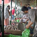 People busy purchasing onion and potatoes from vendors at weekly Sunday Bazaar, Peshawar Morr in Federal Capital