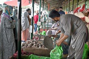 People busy purchasing onion and potatoes from vendors at weekly Sunday Bazaar, Peshawar Morr in Federal Capital