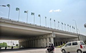 A vendor displaying national flags and other items to attract the customers at his roadside setup in connection with upcoming Independence Day celebrations in Federal Capital.