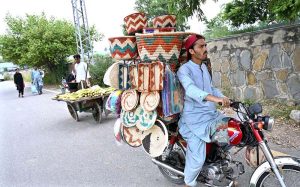 A vendor on his motorcycle loaded with handmade items to attract the customers.