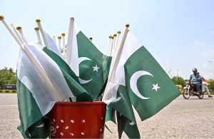 A vendor displaying national flags and other items to attract the customers at his roadside setup in connection with upcoming Independence Day celebrations in Federal Capital.