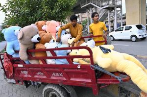 A vendor displaying huge teddy bears on tricycle loader to attract the customers at his roadside setup