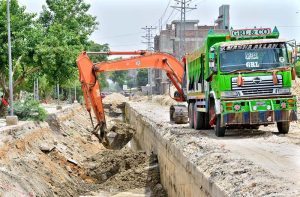 A view of construction work of sewerage nala with help of heavy machine during development work in the city at Sehrish nagar.