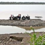 Labourers loading sand on tractor trolley at the right bank of Indus River near Aqil Village to supply to the customers.