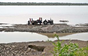 Labourers loading sand on tractor trolley at the right bank of Indus River near Aqil Village to supply to the customers.