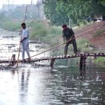 WASA workers are busy cleaning sewerage nullah during rain in the city