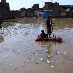 Rain affected people passing through rain flooded water with help of handmade boats due to heavy rain Fatima Jinnah colony