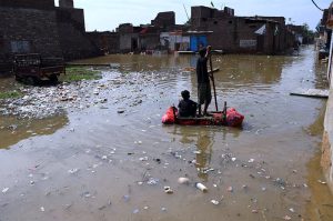Rain affected people passing through rain flooded water with help of handmade boats due to heavy rain Fatima Jinnah colony