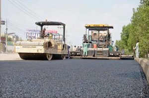 Ongoing road carpeting work at Wapda Town with asphalt paving machinery as part of the city-wide infrastructure development project.