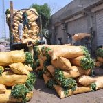 Labourers are busy unloading sacks of vegetables from the delivery truck