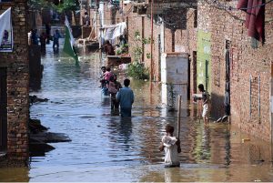 Rain affected people passing through rain flooded water with help of handmade boats due to heavy rain Fatima Jinnah colony