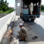 A welder is busy welding a newly installed pipeline at the 10th Avenue flyover as part of ongoing development work in the Federal Capital