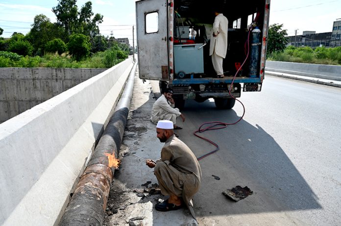 A welder is busy welding a newly installed pipeline at the 10th Avenue flyover as part of ongoing development work in the Federal Capital