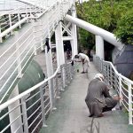 Workers busy painting a pedestrian bridge at Expressway in the Federal Capital
