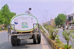 PHA staffer busy watering plants along the greenbelt at old Shujabad Road