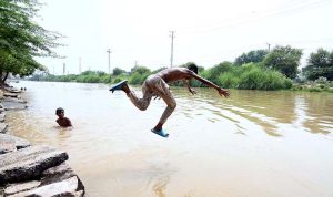 A youngster dives into a canal to cool off and seek relief from the intense heatwave gripping the city.