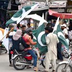 Young vendors displaying and selling national flags at Ganpat Road in the provincial capital ahead of the upcoming Independence Day celebrations