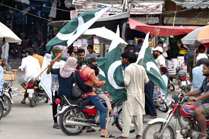 Young vendors displaying and selling national flags at Ganpat Road in the provincial capital ahead of the upcoming Independence Day celebrations