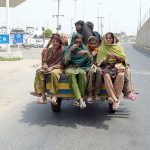 Gypsy women travel on a tricycle rickshaw on their way through the city