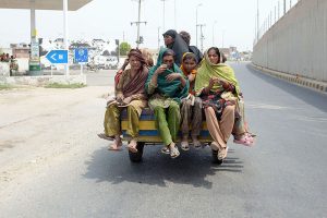Gypsy women travel on a tricycle rickshaw on their way through the city