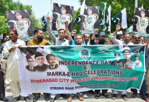 Participants march in the "Marka-e-Haq" Independence Day rally, organized by the Hyderabad City Welfare Organization at Court Road.