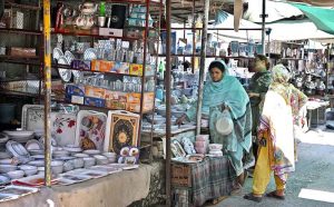 A family purchasing toys from an elderly vendor’s stall at I-9/4 bazaar in the Federal Capital.