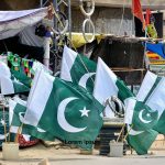 A vendor displays national flags and festive items of Independence Day at his roadside stall in Latifabad, drawing customers ahead of the 78th Independence Day celebrations.