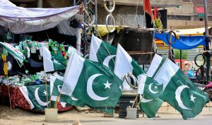 A vendor displays national flags and festive items of Independence Day at his roadside stall in Latifabad, drawing customers ahead of the 78th Independence Day celebrations.