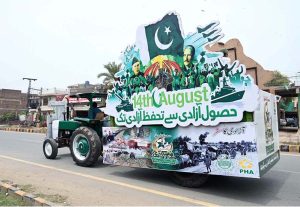 PHA staff taking a tractor float designed with flags and portraits on a round through city streets as part of Independence Day celebrations.