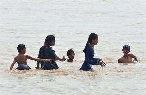 Children diving into the Indus River for swimming after rising water levels caused by heavy monsoon rains. Experts advise caution to avoid any mishap.